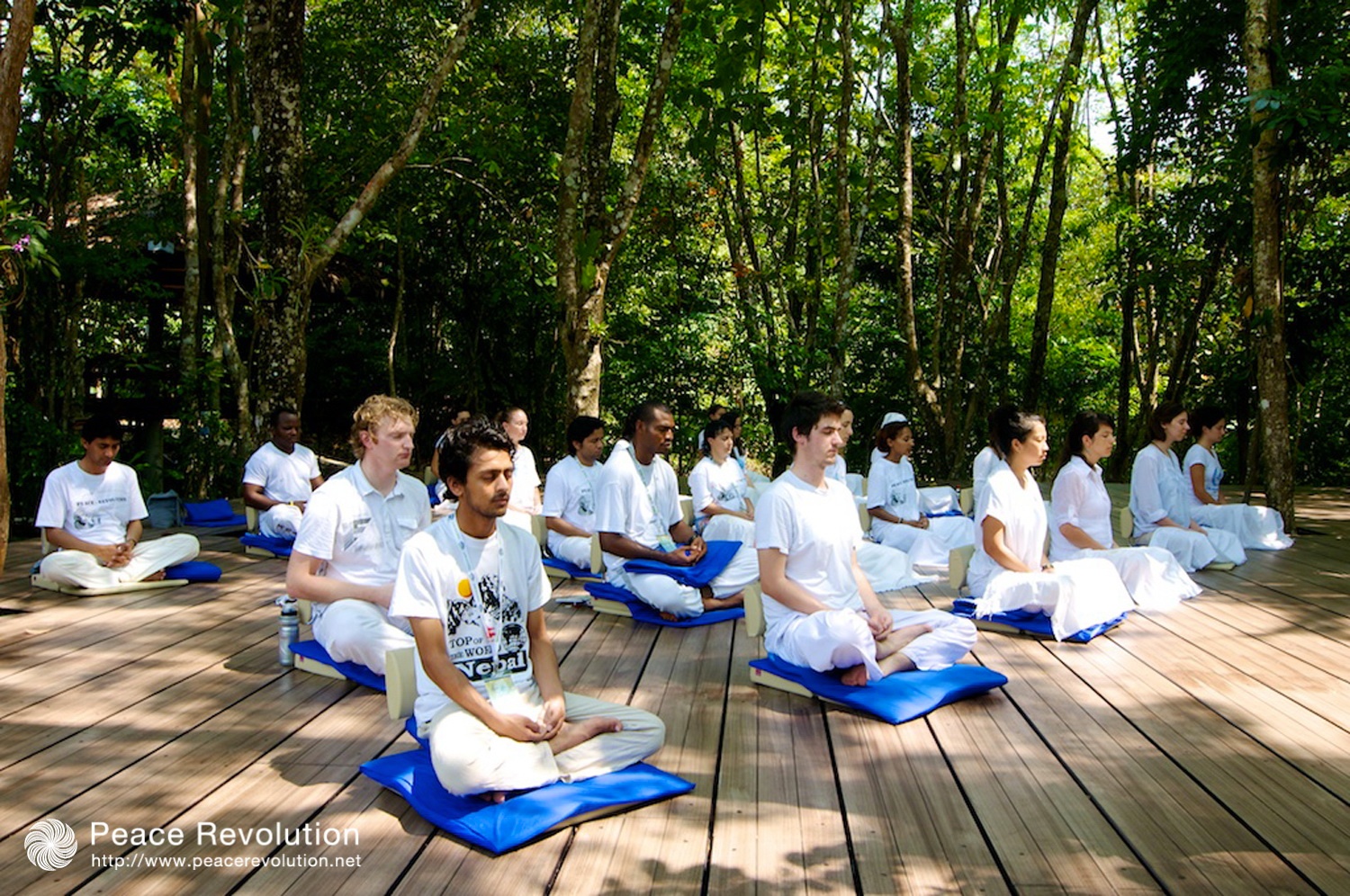 Participants are meditating together in a serene and picturesque setting.