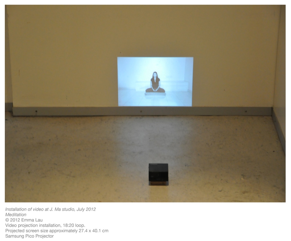 A photo of Emma meditating projected onto the wall